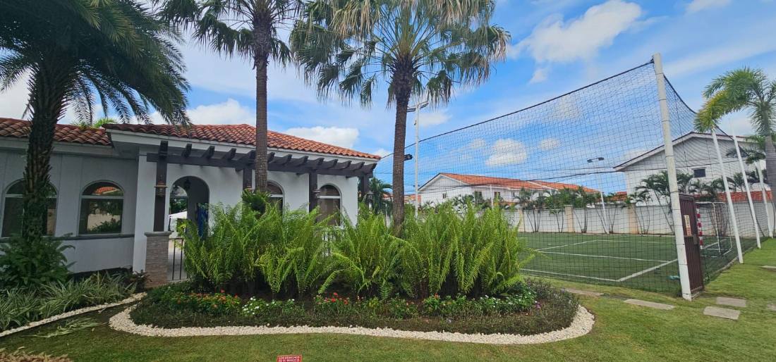 Jardín de casa club con palmas y helechos
