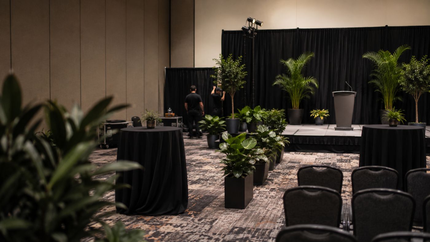 Evento corporativo ambientado con palmas y follaje